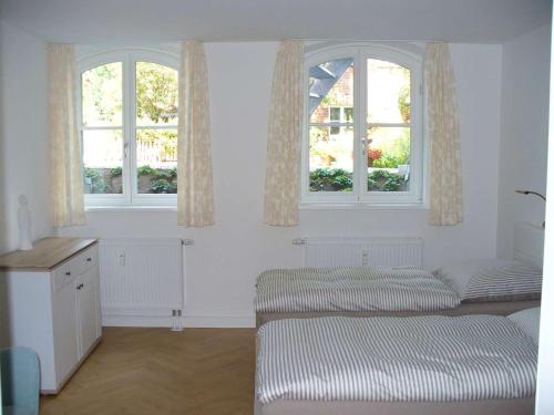 吕讷堡Ferienwohnung Riedner的白色的客房设有两张床和两个窗户。