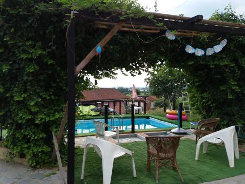 阿斯蒂卡萨塔瓦索酒店的一个带椅子的凉亭和一个庭院内的游泳池