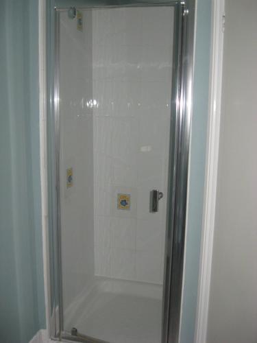 伊斯特布恩伊斯特布恩莱美酒店的浴室里设有玻璃门淋浴