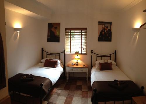 克劳利Tanglewood Gatwick Bed & Breakfast的客房设有两张床和窗户。