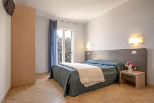 圣温琴佐Residence Villa Lo Scoglietto的一间卧室设有一张大床和一个窗户。