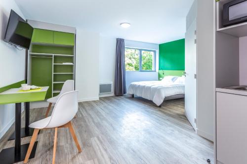 Vern-sur-SeicheAtao Residence- Rennes Sud的一间卧室配有一张床和一张桌子及椅子