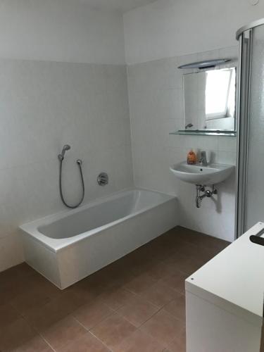 施泰纳赫布伦纳Ferienwohnung "Die 14"的白色的浴室设有浴缸和水槽。