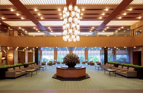 神户神户大仓酒店的一个带椅子和吊灯的大型大堂