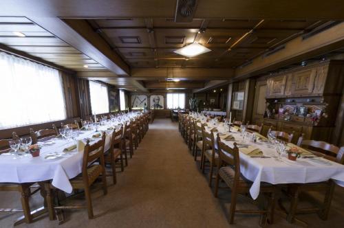 穆奥塔塔尔Gasthaus Post的餐厅的一排餐桌,配有白色桌布