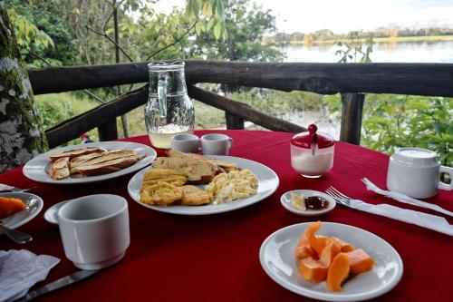 Puerto NariñoEware Refugio Amazonico的红色桌布上带食物盘的桌子