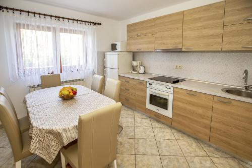 巴斯卡Apartments Juranić的带桌椅的厨房和带水槽的厨房