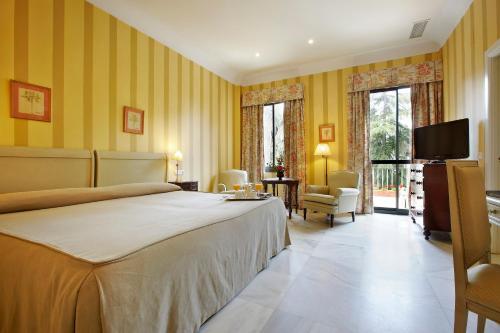 赫雷斯-德拉弗龙特拉赫雷斯别墅酒店的一间卧室配有一张大床和电视