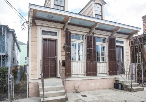 新奥尔良New Orleans Hideaway的街上的一间小房子,有棕色的门和楼梯