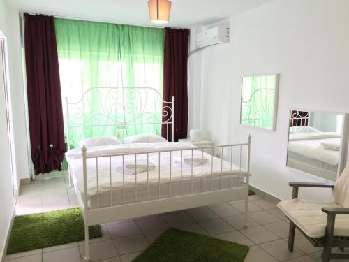 布加勒斯特Green Apartment 6的卧室配有白色的床和窗户。