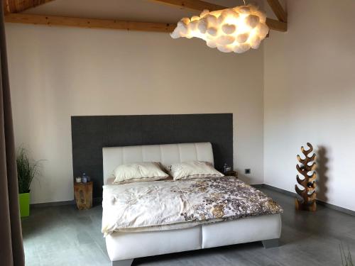 雷德尼斯Vila Pod Zámkem Lednice的一间卧室配有一张白色的床和黑色床头板