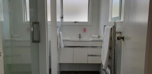 罗托鲁瓦Rose Apartments Unit 3 Central Rotorua - Accommodation & Spa的白色的浴室设有水槽和镜子