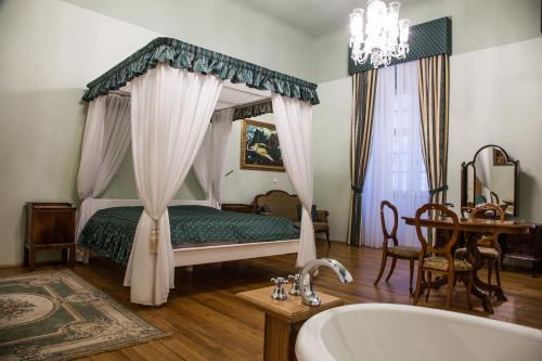 兹诺伊莫Althanský palác的一间卧室配有一张带浴缸和桌子的床。