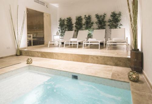 斯利马双枕精品旅舍的一座带椅子和植物的游泳池
