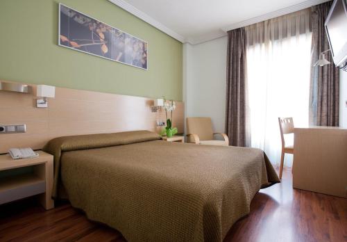 马德里布拉沃穆里略4C酒店的酒店客房带一张床、一张桌子和椅子