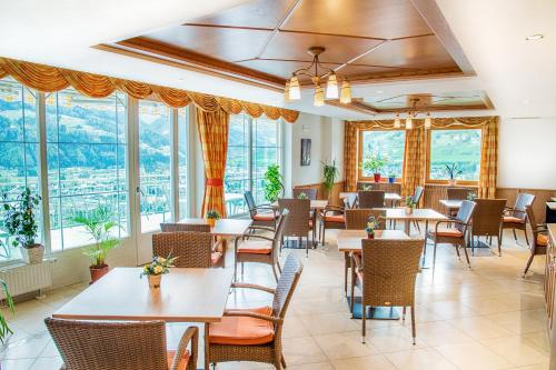 维皮泰诺Hotel Sonnenheim的餐厅设有桌椅和窗户。