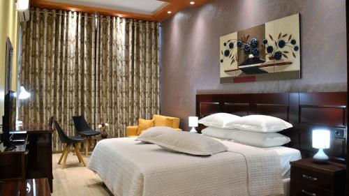 费里Comfort Hotel的卧室配有一张带白色床单和枕头的大床。