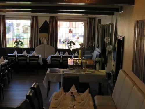博尔肯Gasthof Einhaus的用餐室设有桌椅和窗户。