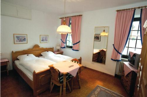 博尔肯Gasthof Einhaus的一间卧室配有一张床、一张桌子和一台电视