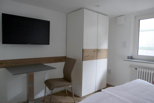 杜塞尔多夫Messeappartement Unterrath的一间卧室配有一张床、一把椅子和电视。