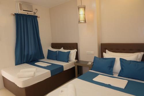 爱妮岛Laule'a Hostel的蓝色和白色的客房内的两张床
