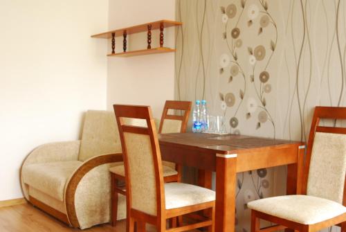 格但斯克Mieszkanie Jelitkowo的一间带桌椅和沙发的用餐室