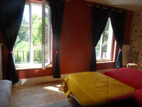 RevinGîte "La Maison"的一间卧室设有两张床和两个窗户。