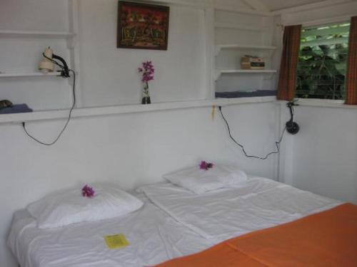 温沃德赛德埃尔莫末小屋旅馆的卧室配有白色的床和2个枕头