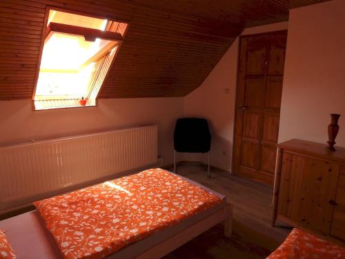 BárBarackos Vendégház Bár的一间卧室设有一张床、一个窗口和一把椅子