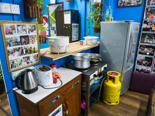 金马仑高原兰花天堂旅舍的厨房配有柜台和冰箱。