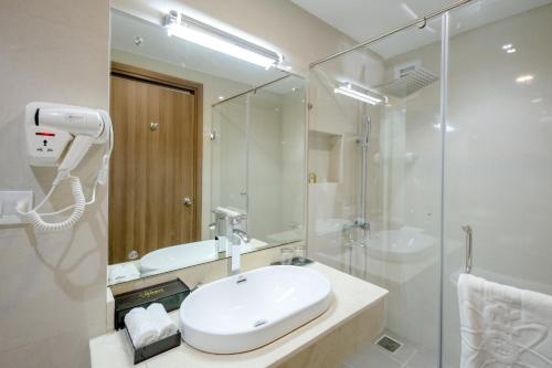 芽庄Orbit Hotel的白色的浴室设有水槽和淋浴。