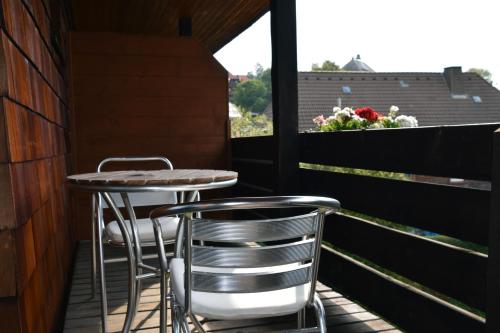 施卢赫湖Pension am See的阳台配有两把椅子和一张桌子,还有一个窗户。