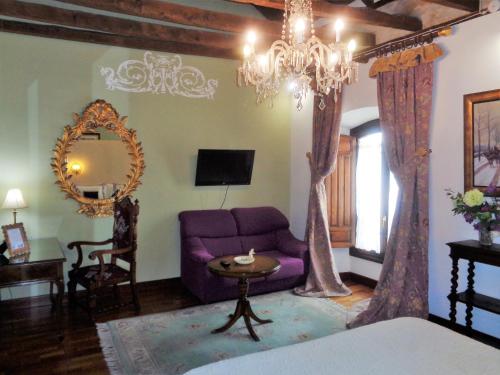 乌贝达Hotel Boutique Nueve Leyendas的客厅配有紫色沙发和吊灯。