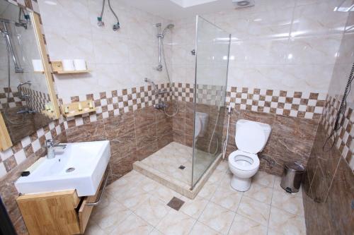 迪拜扎吉酒店的浴室配有卫生间、淋浴和盥洗盆。