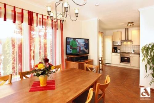 卡尔斯哈根Haus Seeschwalbe的厨房以及带桌子和电视的用餐室。