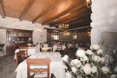 格罗塔米纳尔达Il Vecchio Frantoio的一间设有白色桌椅和鲜花的餐厅