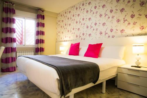 马拉加Holidays2Malaga Victoria High Speed WIFI的卧室配有带红色枕头的大型白色床
