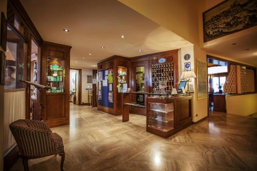 圣马力诺蒂塔诺酒店的铺有木地板的客厅和带椅子的房间