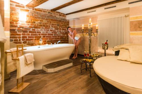 施特拉尔松德施特拉尔松斯科勒霍夫浪漫酒店的站在带浴缸的浴室中的女人
