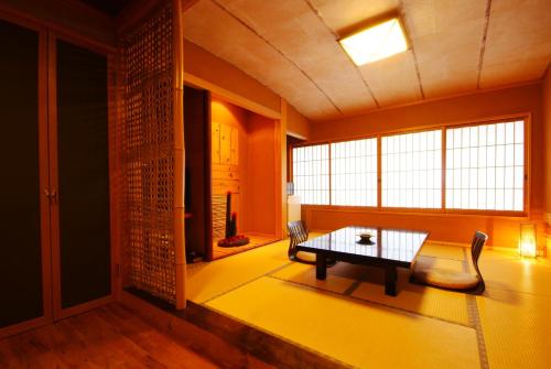 丰冈市城崎温泉 但馬屋-Tajimaya-的客厅配有桌子、沙发和窗户