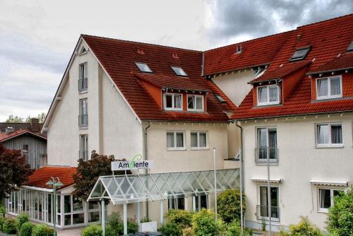 瓦尔多夫阿姆比杨特沃尔德芙酒店的一座白色的大建筑,有红色的屋顶