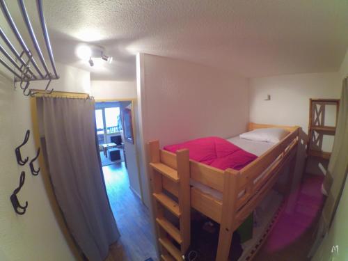 阿沃里亚兹Appartement Studio Avoriaz的一间卧室配有带红色床单的双层床