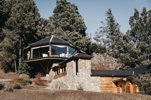 圣马丁德洛斯Arrayan Lake View Mountain Lodge & Casa De Te Arrayan的大楼顶部的玻璃房子