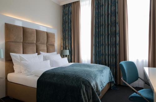 雷达-维登布吕克鲁宁城堡公园酒店的酒店客房,配有一张床和一张蓝色椅子