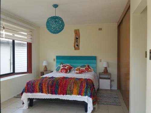 迪卡托Casa en Pingueral的一间卧室配有一张带彩色毯子的床