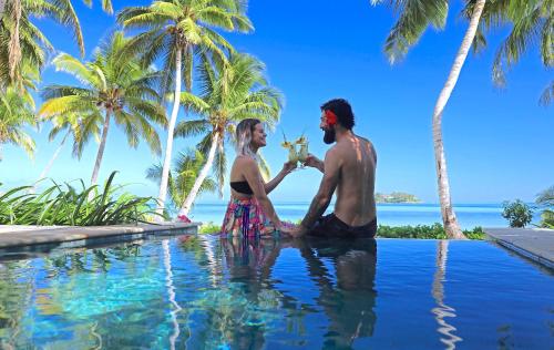 马洛洛Tropica Island Resort-Adults Only的坐在游泳池里的男人和女人
