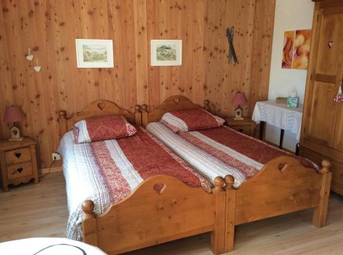 ChoexLa Bergerie - chalet Alice的一间卧室配有一张带两个枕头的木床