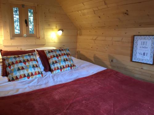 圣阿尔班Cabane Aligoté的小木屋内一间卧室,配有一张床