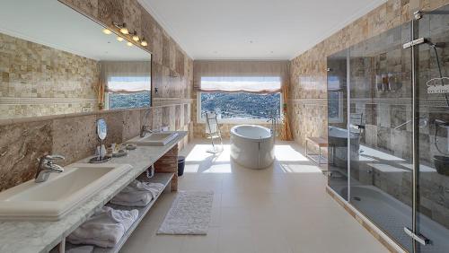罗夫莱多德查韦拉洛杉辛科恩布罗斯酒店的浴室配有2个盥洗盆、浴缸和淋浴。
