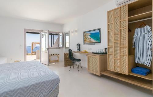 Agia Kiriaki BeachPsaravolada Hotel Milos的一间卧室配有一张床、一张桌子和一张书桌。